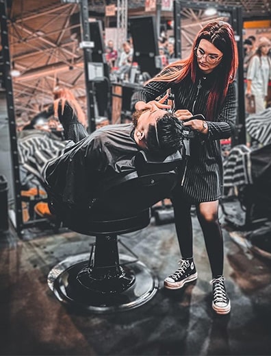 Alison Bochard lors d'un concours de coiffure qui taille une barbe avec passion